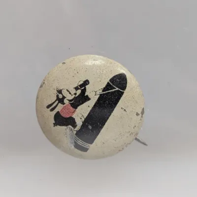 Sale Photo Thumbnail #52: Vintage World War II-era celluloid pinback button featuring Mickey Mouse riding a bomb.