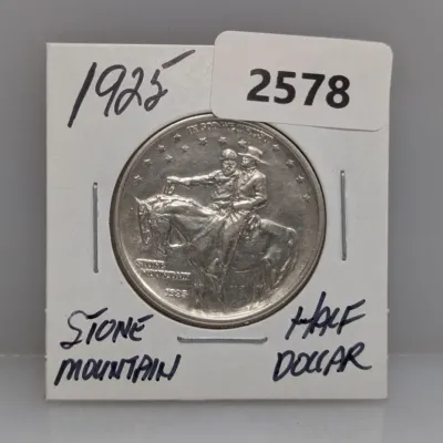 Sale Photo Thumbnail #903: 1925 Stone Mountain Memorial silver commemorative half dollar coin housed in a protective cardboard flip.