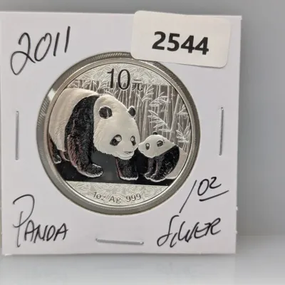 Sale Photo Thumbnail #869: 2011 Chinese Silver Panda 10 Yuan coin, 1 oz .999 fine silver, housed in a protective cardboard flip holder.