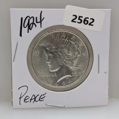Sale Photo Thumbnail #887: 1924 Peace silver dollar coin presented in a cardboard protective flip holder.