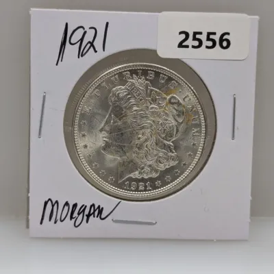 Sale Photo Thumbnail #881: 1921 Morgan silver dollar coin displayed in a cardboard coin flip.