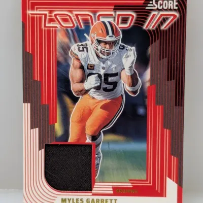 Sale Photo Thumbnail #558: Panini Score "Zoned In" Myles Garrett Cleveland Browns trading card featuring an embedded black jersey relic patch.