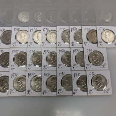 Sale Photo Thumbnail #916: Collection of twenty-two 1976 Eisenhower Bicentennial dollar coins, each individually housed in cardboard coin flips.