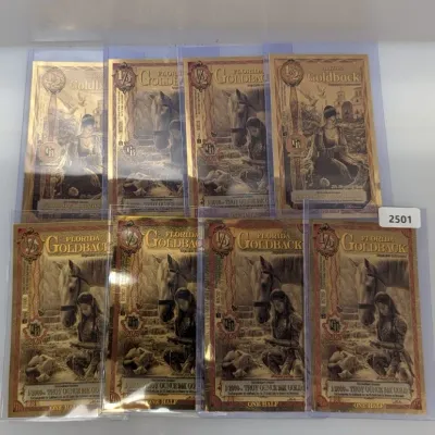 Sale Photo Thumbnail #826: Collection of eight 1/2 Goldback 24K gold foil notes from Arizona and Florida, each housed in a protective sleeve.
