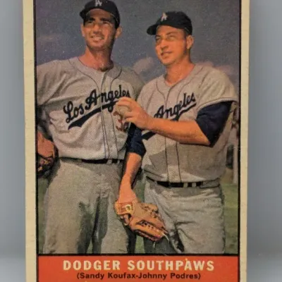 Sale Photo Thumbnail #259:  Vintage 1960 Topps baseball card #302, 'Dodger Southpaws' featuring Sandy Koufax and Johnny Podres, showing slight edge wear.