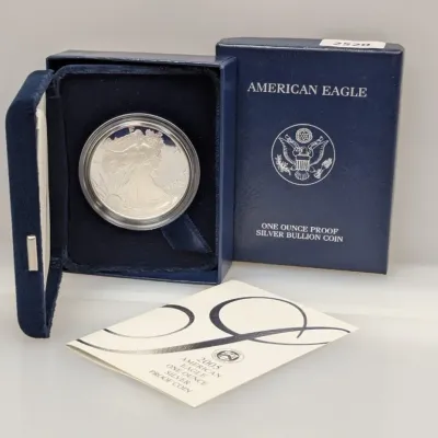 Sale Photo Thumbnail #845: 2005 American Eagle One Ounce Proof Silver Bullion Coin, housed in its original protective capsule, blue velvet display case, outer box, and Certificate of Authenticity.