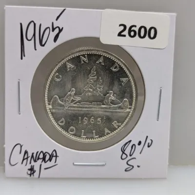 Sale Photo Thumbnail #925: 1965 Canadian silver dollar featuring the classic Voyageur design, encased in a cardboard coin flip holder.