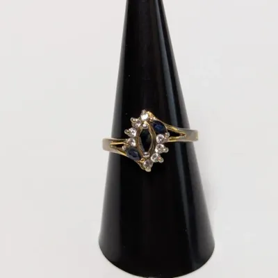 Sale Photo Thumbnail #809: Gold-tone cluster ring featuring marquise-cut sapphire-style stones surrounded by clear accent stones, displayed on a black ring cone.