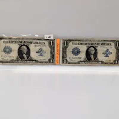 Sale Photo Thumbnail #842: Pair of Series 1923 $1 Silver Certificates, known as large-size "blanket notes," both housed in protective plastic sleeves.