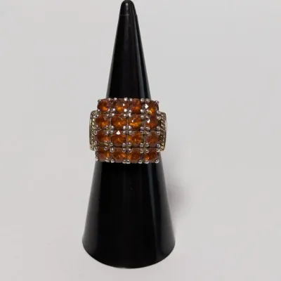 Sale Photo Thumbnail #801: Vintage cluster ring featuring a grid-set array of round amber-toned faceted gemstones on a black ring cone display.