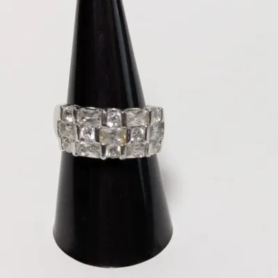 Sale Photo Thumbnail #792: Silver-tone costume ring featuring three rows of square-cut clear cubic zirconia or glass stones, displayed on a black ring cone.