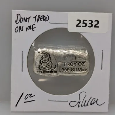 Sale Photo Thumbnail #857: One troy ounce .999 fine silver bar featuring the Gadsden rattlesnake logo and "Don't Tread On Me" slogan, housed in a cardboard coin flip holder.