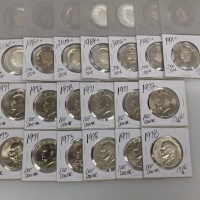Sale Photo Thumbnail #917: Collection of US coins in cardboard flips, including Kennedy half dollars and Eisenhower dollar coins dating from 1971 to 2020.