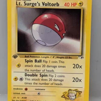 Sale Photo Thumbnail #401: 1st Edition Lt. Surge's Voltorb Pokémon trading card, #84/132 from the Gym Heroes set, copyrighted 2000 Wizards of the Coast.