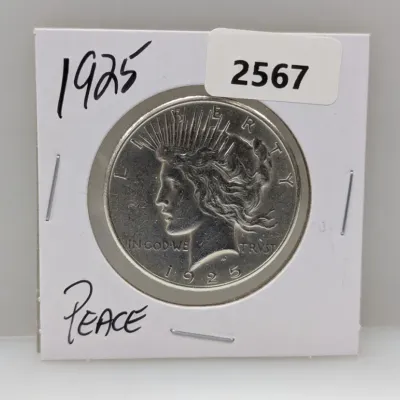 Sale Photo Thumbnail #892: 1925 Peace silver dollar housed in a cardboard coin flip holder.