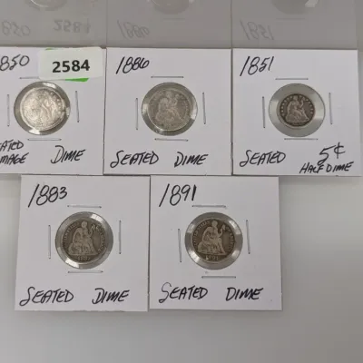 Sale Photo Thumbnail #909: Collection of five 19th-century Seated Liberty silver coins, including dimes and a half dime, individually housed in cardboard coin flips.