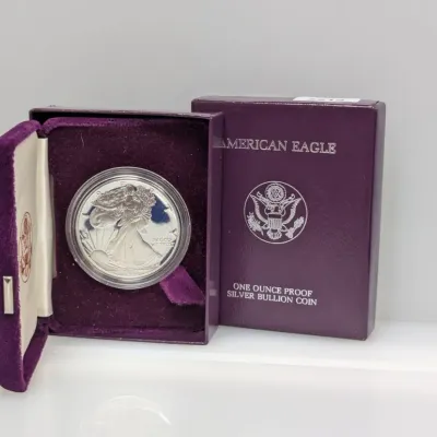 Sale Photo Thumbnail #844: American Eagle one ounce proof silver bullion coin in its original purple velvet display case and outer sleeve box.