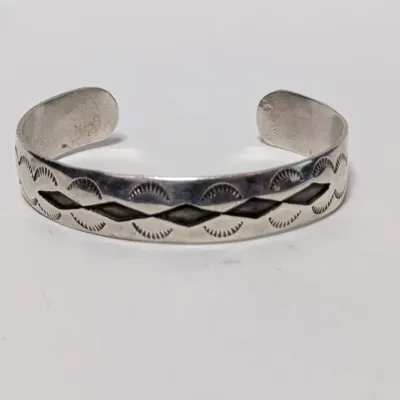 Sale Photo Thumbnail #815: Native American style sterling silver cuff bracelet featuring stamped geometric geometric and diamond designs.