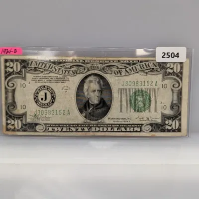 Sale Photo Thumbnail #829: Series of 1934-B $20 Federal Reserve Note featuring Andrew Jackson, enclosed in a protective plastic sleeve.