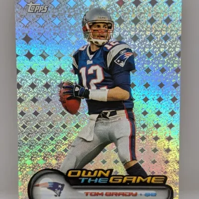 Sale Photo Thumbnail #157: Topps Own the Game Tom Brady foil football card featuring a holographic diamond pattern finish.