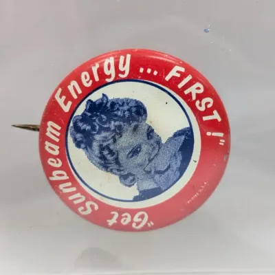 Sale Photo Thumbnail #147: Vintage Sunbeam Bread advertising pinback button reading 'Get Sunbeam Energy... FIRST!' with Little Miss Sunbeam graphic.