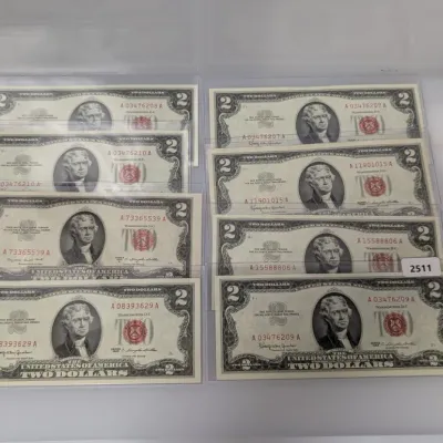 Sale Photo Thumbnail #836: Collection of eight vintage Series 1963 $2 United States Legal Tender notes with red seals, housed in clear protective sleeves.