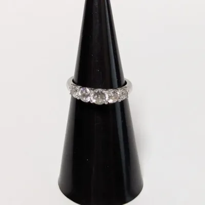 Sale Photo Thumbnail #803: Five-stone diamond anniversary ring set in a polished white gold or platinum band, displayed on a black ring cone.