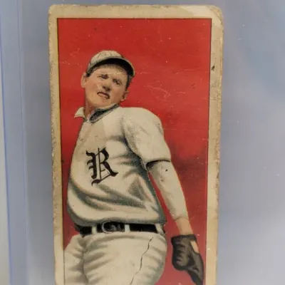 Sale Photo Thumbnail #32: Vintage T206 tobacco baseball card depicting Chappelle of Rochester with a red background, housed in a protective top loader holder.