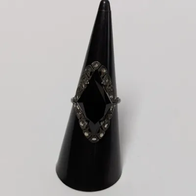 Sale Photo Thumbnail #811: Vintage sterling silver and marcasite ring featuring a marquise-cut black onyx center stone, displayed on a black ring cone.