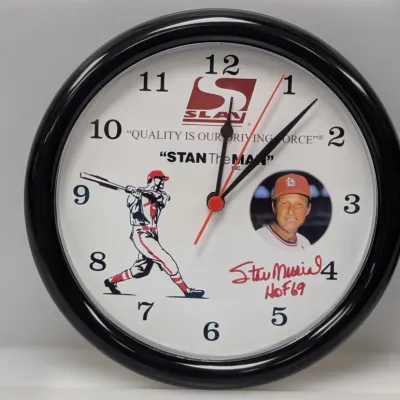 Sale Photo Thumbnail #8: Stan Musial promotional wall clock featuring St. Louis Cardinals branding, graphic illustration, photo portrait, and printed replica signature.