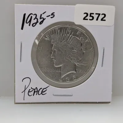 Sale Photo Thumbnail #897: 1935-S Peace silver dollar coin in a protective cardboard flip holder.