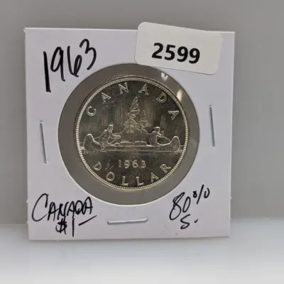 Sale Photo Thumbnail #924: 1963 Canadian 80% silver voyager dollar coin, housed in a cardboard flip holder.