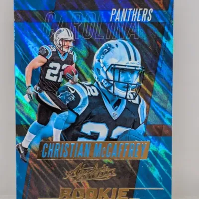 Sale Photo Thumbnail #133: 2017 Panini Absolute Football Christian McCaffrey Rookie Roundup holographic insert card in Carolina Panthers uniform.