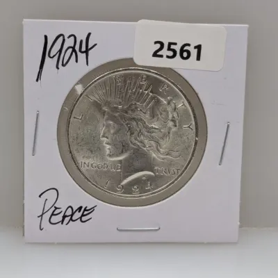 Sale Photo Thumbnail #886: 1924 Peace Silver Dollar coin in a cardboard protective flip holder.