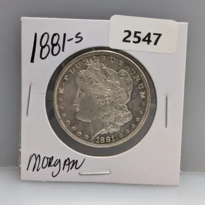 Sale Photo Thumbnail #872: 1881-S Morgan silver dollar coin, stored in a cardboard flip holder.