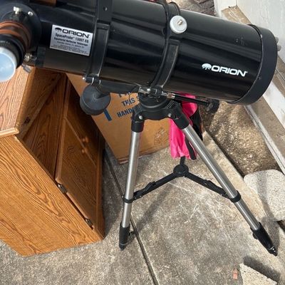 Sale Photo Thumbnail #37: Orion SpaceProbe 130ST EQ reflector telescope mounted on an adjustable metal tripod.