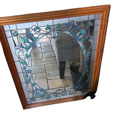 Sale Photo Thumbnail #24: Large wooden-framed mirror featuring an Art Nouveau-style stained glass floral overlay design around the perimeter in shades of blue and green.