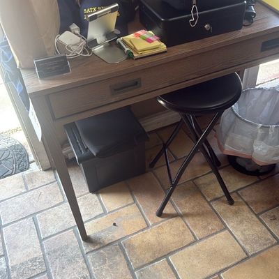 Sale Photo Thumbnail #50: Modern wooden writing desk with a single drawer, paired with a black folding stool and various office supplies.