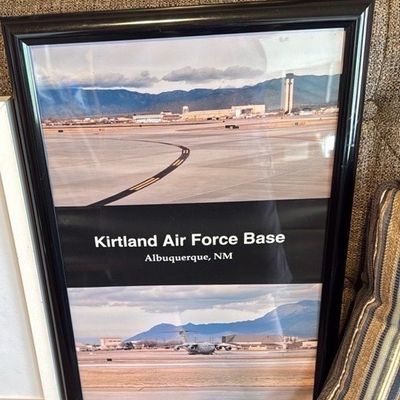 Sale Photo Thumbnail #3: Framed commemorative print of Kirtland Air Force Base in Albuquerque, New Mexico, featuring airfield views and a military transport aircraft.