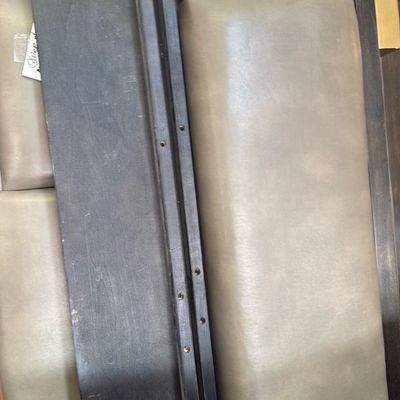 Sale Photo Thumbnail #16: Dismantled modern wooden bed frame components, featuring dark-stained wood rails and taupe leather upholstered panel sections with brass accents.