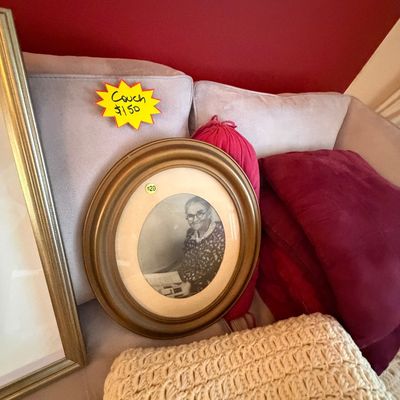 Sale Photo Thumbnail #84: Vintage framed oval portrait photo of an elderly woman resting on a light-colored sofa with burgundy accent pillows.