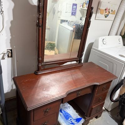 Sale Photo Thumbnail #122: Vintage mahogany vanity with an attached swivel mirror, featuring seven drawers with brass batwing pulls and a broken mirror glass.