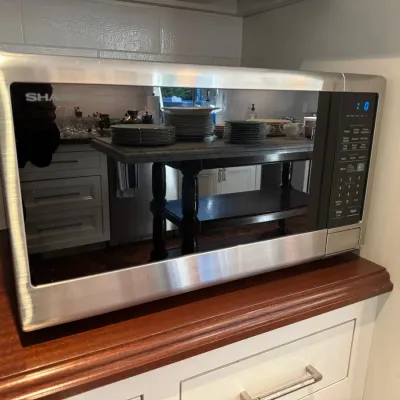 Modern Sharp countertop microwave oven featuring a stainless steel housing and mirrored glass door.