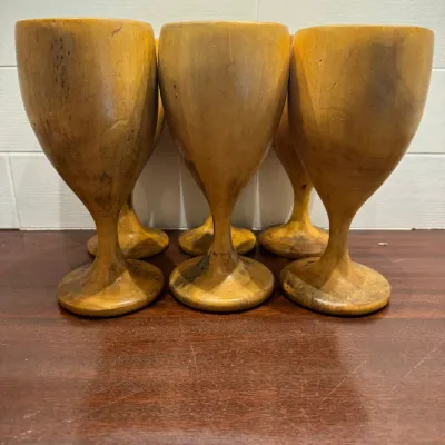 Set of vintage hand-turned wooden goblets with natural grain variations and smooth finish.