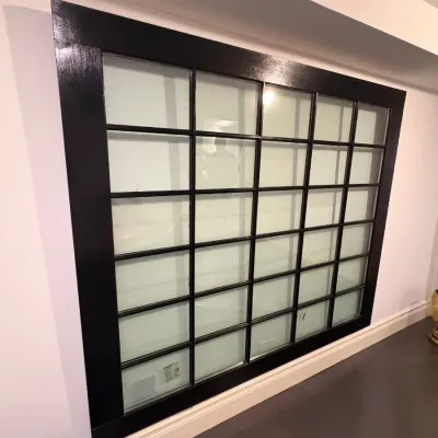 Sale Photo Thumbnail #134: Large multi-pane glass wall mirror framed in black-painted wood, featuring a grid of individual divided lite sections.