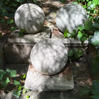 Sale Photo Thumbnail #150: Trio of weathered concrete garden sphere ornaments, each resting on an integral square pedestal base.