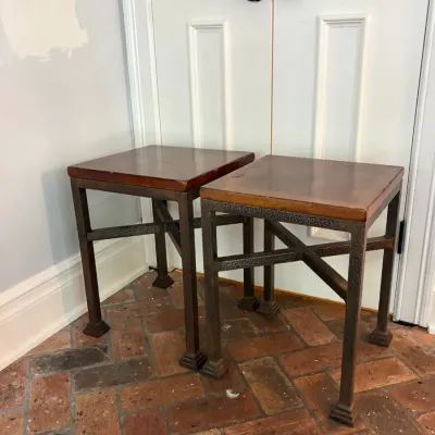 Sale Photo Thumbnail #113: Pair of industrial-style side tables featuring textured metal frames with cross-stretchers and wooden tops.