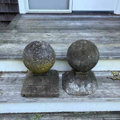 Pair of vintage weathered concrete or stone spherical garden finials with square pedestal bases.