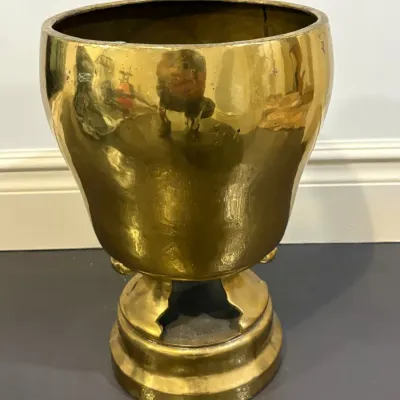 Sale Photo Thumbnail #132: Vintage polished brass pedestal planter featuring a urn-shaped body resting on a tiered base, showing minor tarnish and age-related surface wear.