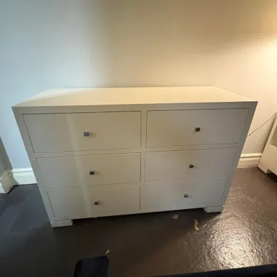 Sale Photo Thumbnail #129: Contemporary white six-drawer dresser with square metallic knobs, set on low block feet.